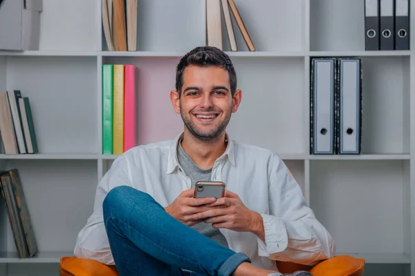 Homem Atraente Casa Com Telefone Móvel Sorrindo — Fotografia de Stock