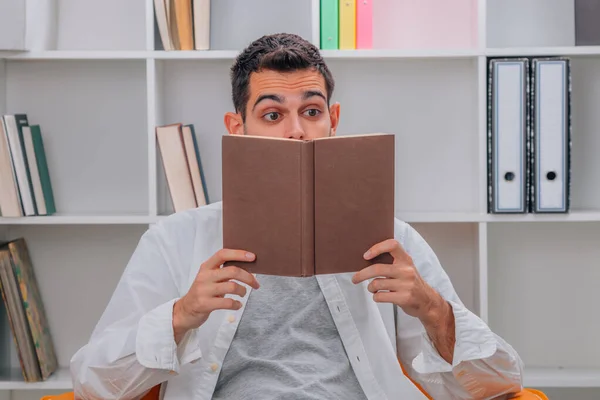 Homem Casa Lendo Livro Com Expressão Surpresa — Fotografia de Stock