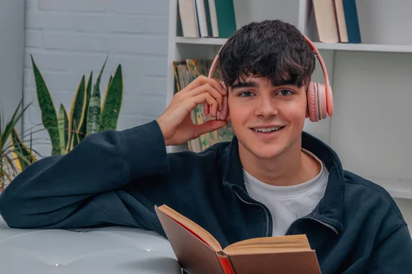 Joven Casa Leyendo Libro Escuchando Música Con Auriculares —  Fotos de Stock
