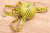 jablko s měřicí páskou na dřevěném pozadí, dieta