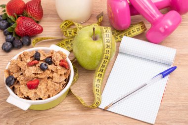 Mısır gevreği, meyve, dambıl ve diyet kontrolü için not defteri olan sağlık ve zayıflatma fonu