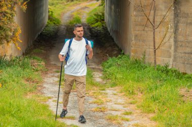 Sırt çantalı bir adam dışarıda yürüyüş yapıyor.