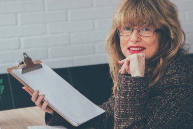 Ofisteki kadın belgelerle çalışıyor.