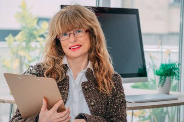 Ofisteki kadın belgelerle çalışıyor.