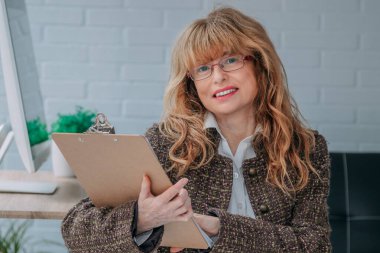 İş kadını evrak klasörüyle gülümsüyor