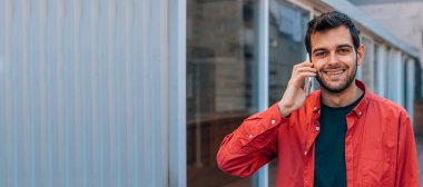 Sokak ortasında cep telefonu kullanan şehir tarzı bir adam.