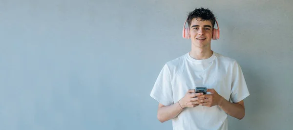 Adolescente Con Teléfono Móvil Auriculares Escuchando Música Aislada Pared Con — Foto de Stock