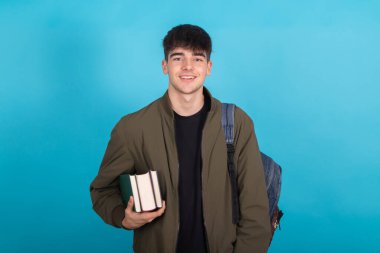 Arkaplanda kitap ve sırt çantası olan genç bir öğrenci var.