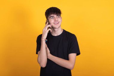 Cep telefonu ya da cep telefonuyla konuşan izole bir genç çocuk.