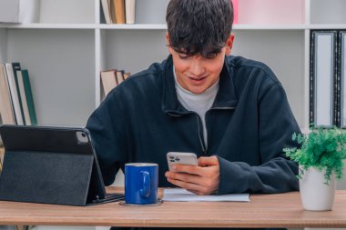 Bilgisayarı ve cep telefonu olan bir öğrenci.