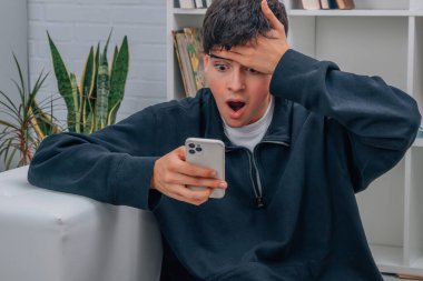 Evdeki genç çocuk cep telefonuna bakarken şaşkına döndü.