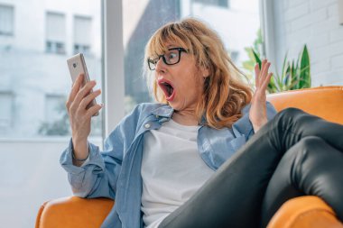 Cep telefonuna bakan orta yaşlı bir kadın hayrete düşmüş ve şaşırmıştı.