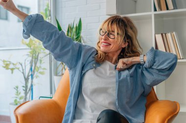 Evdeki başarıyı kutlayan coşkulu kadın.