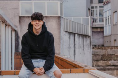 young trendy urban teenager sitting on the street