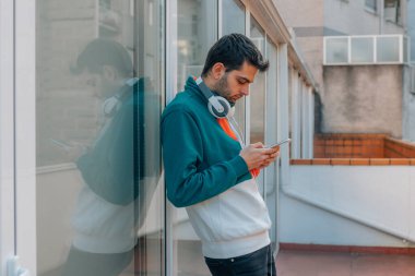 Sokakta cep telefonu olan genç bir adam.