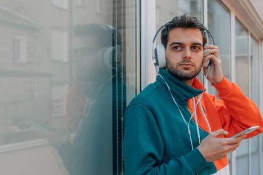 Sokaktaki genç adam cep telefonu ve kulaklığı ile