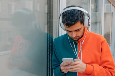Sokaktaki genç adam cep telefonu ve kulaklığı ile