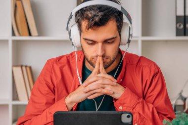 young man with headphones and laptop attentive to the online course