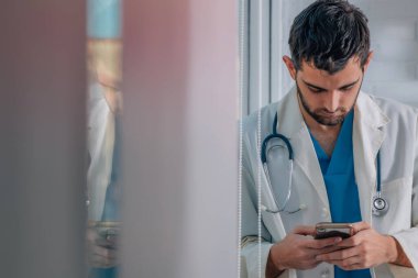 Cep telefonu olan genç bir doktor.