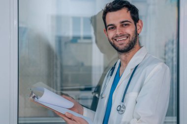 Hastanede üniformalı ve steteskoplu bir doktor var.