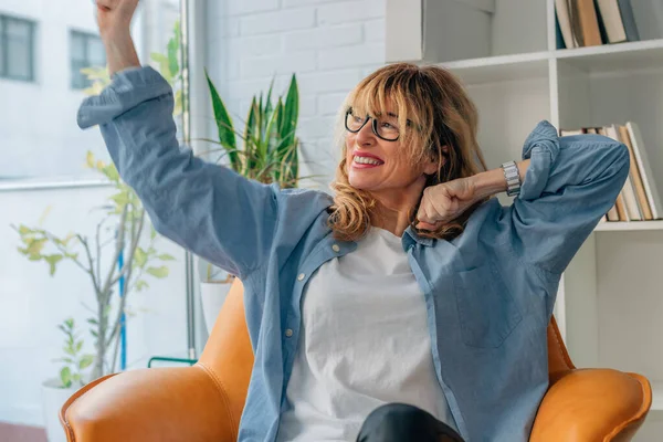 Evdeki başarıyı kutlayan coşkulu kadın.