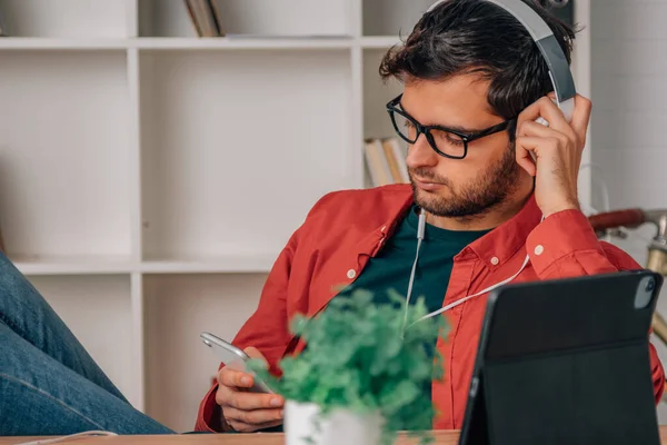 Joven Casa Con Teléfono Móvil Auriculares Escuchando Música —  Fotos de Stock