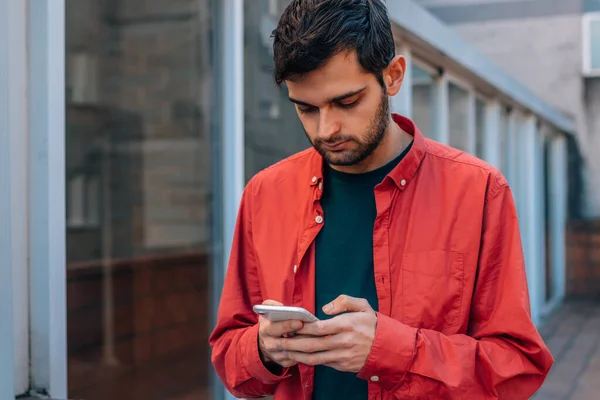 Man Med Mobiltelefon Gatan Med Röd Skjorta Avslappnad Stil — Stockfoto