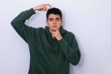 Şüphe ve soru ifadesiyle izole edilmiş genç bir çocuk.