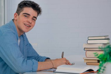 Masada ya da okul masasında kitap yazan öğrenci