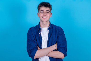 Mavi arka planda izole edilmiş genç çocuk