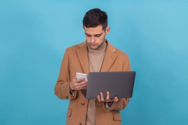 isolated young man with computer and mobile phone