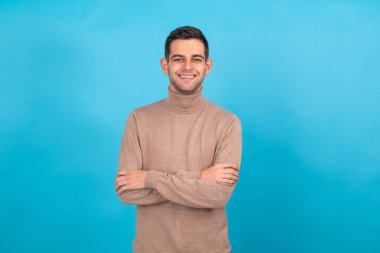 Mavi arka planda izole edilmiş genç bir adam portresi