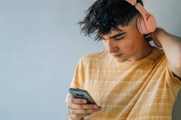 Adolescent Avec Téléphone Portable Écouteurs Sur Fond Mur Gris — Photo