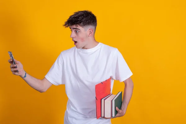 teenage student with mobile phone and books isolated on color background