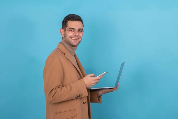 Uomo Con Cappotto Cellulare Computer Isolato Sfondo Blu — Foto Stock