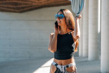 Sokakta cep telefonu olan şehir tarzı bir kız.