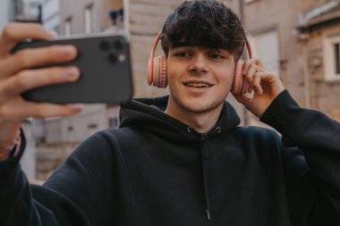 Sokaklarda cep telefonu ve kulaklığı olan bin yıllık genç adam.