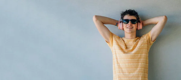 Giovane Uomo Con Occhiali Sole Cuffie Relax Sulla Parete — Foto Stock