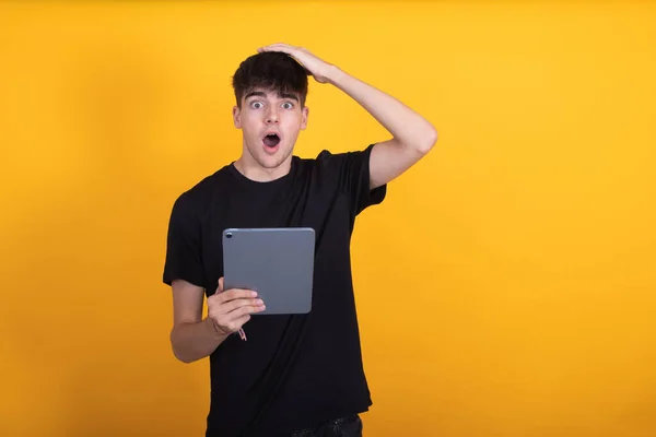 teen student with tablet isolated on background surprised