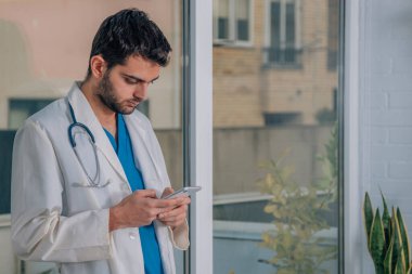 Elinde cep telefonu olan bir doktor.