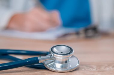 Steteskop ön planda, doktorun masasında.
