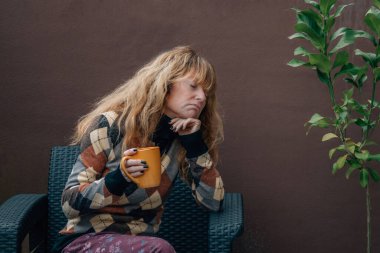 Bunalımlı kadın evde bir fincan kahveyle yalnız.