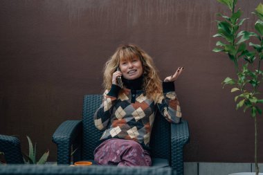 Orta yaşlı bir kadın cep telefonuyla konuşuyor.