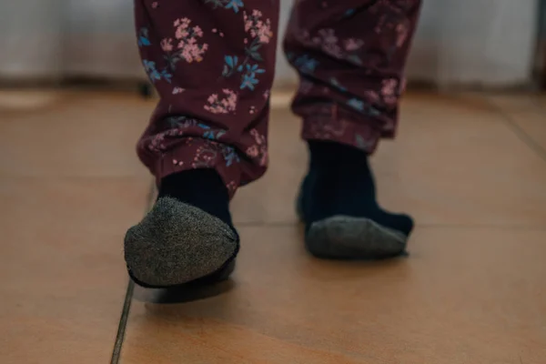 feet with socks walking on the floor barefoot