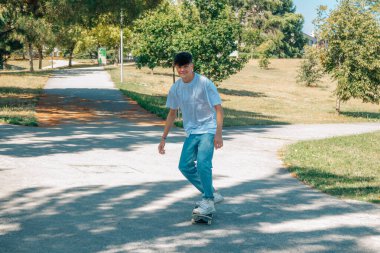 Genç adam sokakta kaykayla pratik yapıyor.