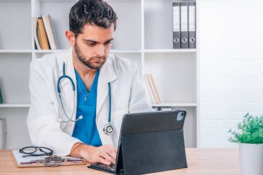 Ofisteki doktor bilgisayarla çalışıyor.