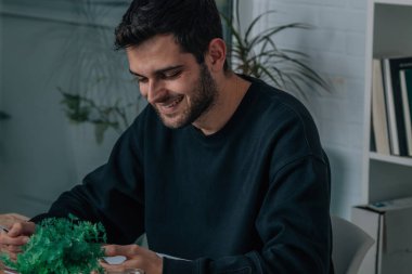 Evde ya da ofiste çalışan cep telefonu ve bilgisayarı olan bir adam