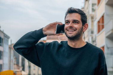 Sokaktaki adam cep telefonuyla konuşuyor.