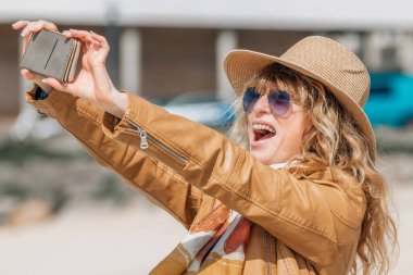 Cep telefonlu turist fotoğraf çekiyor.