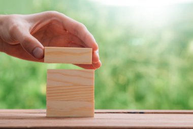 hand placing piece of wood in construction